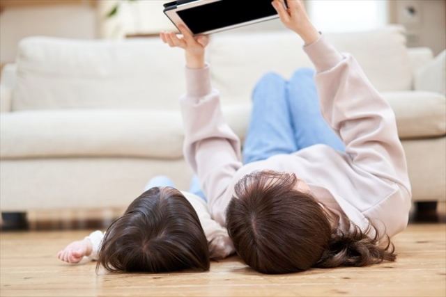 床に寝転ぶ親子